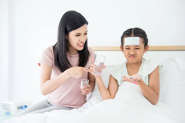 年轻的亚洲女孩拒绝片剂药物和母亲责骂她 — 图库照片