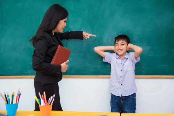 Azjatycka Uczniak Uszy Clse Przez Ręce Uśmiechy Podczas Gdy Nauczyciel — Zdjęcie stockowe