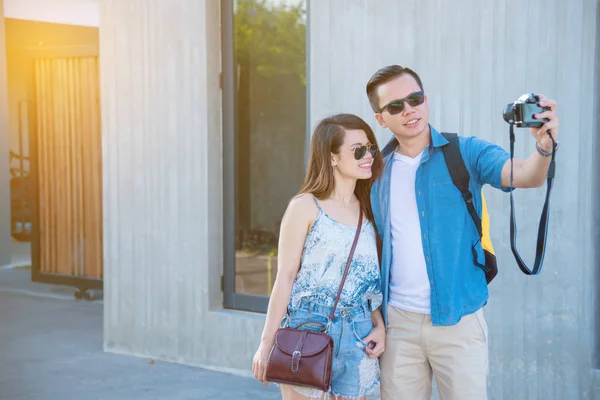 Young asian tourist taking their photo on the street