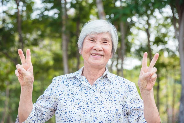 Healthy senior asian woman smiling in park