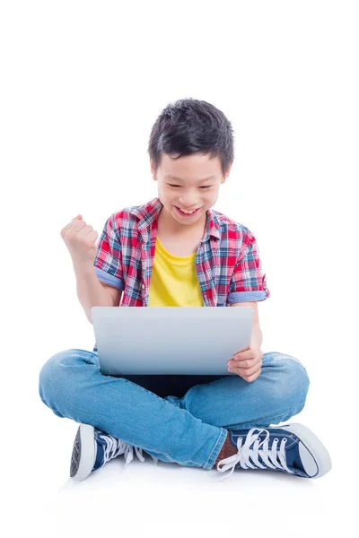 アジアの若い男の子の床に座って 白い背景の上のラップトップ コンピューター上のゲームをプレイ — ストック写真