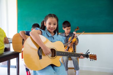 Gitar Okulu sınıf ile gülümseyen güzel Asyalı kız