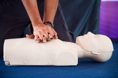 Ellerini bir adamın ilkyardım sınıfında manken üzerinde Cpr pratiği