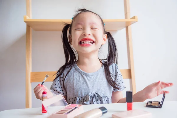 Mała Dziewczynka Azjatyckich Zabawy Podczas Gdy Makijaż Twarzy Kosmetycznych Przez — Zdjęcie stockowe