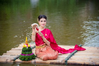 Loy Krathong Festivali bota Nehri üzerinde dua kırmızı Tay geleneksel kıyafet giyen güzel Taylandlı kız
