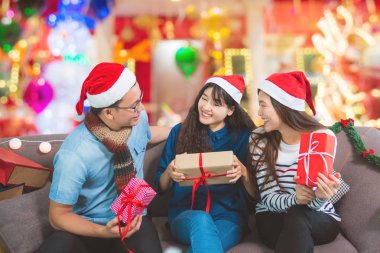 Asya Gençler, bir adam ve iki kadın Noel partisi konuşuyor.