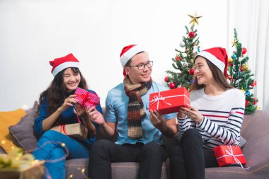 Kadınlar parti Noel hediye kutuları veren Genç Asyalı adam.