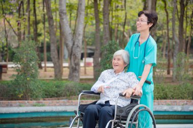 Kadın hemşire Bahçe ile tekerlekli sandalye üzerinde kıdemli mutlu Asya