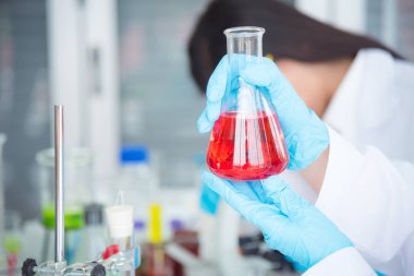 El laboratuvar şişesi tutan bilim adamı