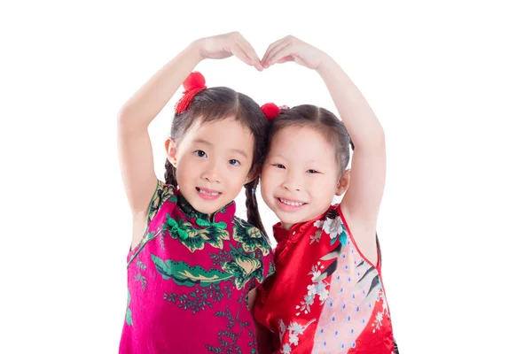 Petites filles chinoises faisant forme de coeur par leurs bras sur blanc — Photo