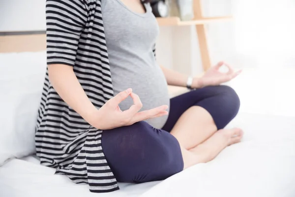 Torso primer plano de la mujer embarazada haciendo ejercicio en interiores . — Foto de Stock