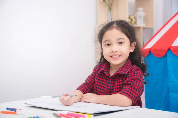 Pouco asiático menina desenho retrato e sorrisos em casa — Fotografia de Stock