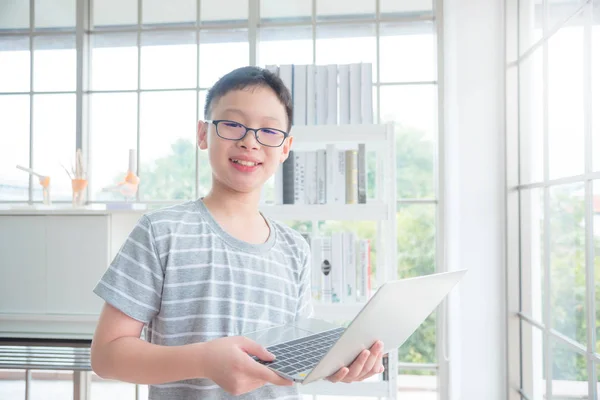 Dizüstü bilgisayar, Kütüphane ve gülümseyen tutan genç Asyalı çocuk — Stok fotoğraf