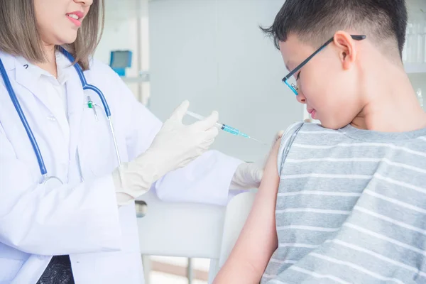 Een arts die vaccineren een jongen in kliniek — Stockfoto