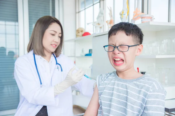 Een arts die vaccineren een jongen in kliniek — Stockfoto