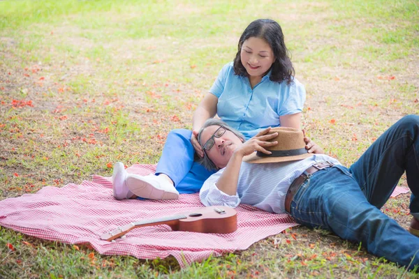 Retrato de casal sênior sentado no parque — Fotografia de Stock