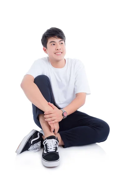Young handsome man wearing white T-shirt sitting and smiles — Stockfoto
