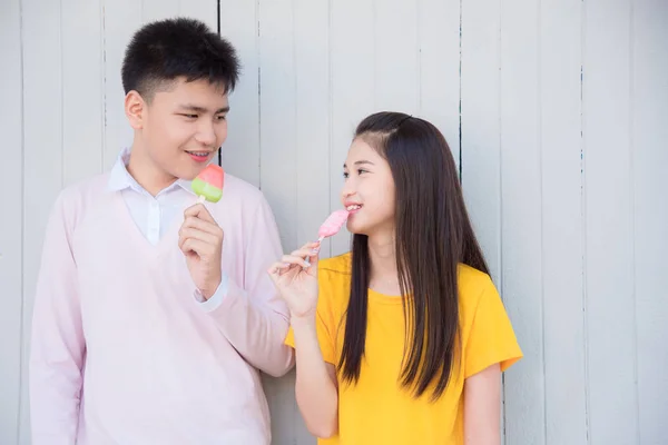 Tiener jongen en meisje staand en eten ijs — Stockfoto