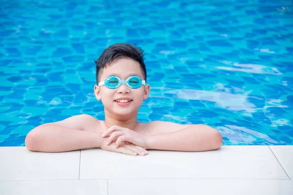 Pojke bär glasögon och leende på simbassängen — Stockfoto
