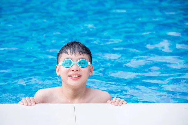 Anak laki-laki mengenakan kacamata dan tersenyum di kolam renang — Stok Foto