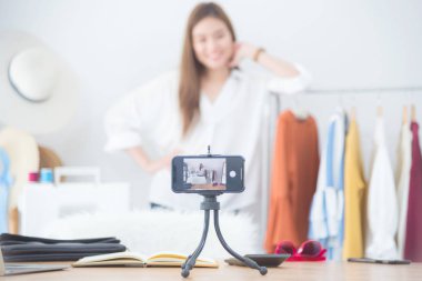 Güzel kadın blogger onu dükkanında vlog video canlı akışı kayıt için kamera önünde giysi gösteren