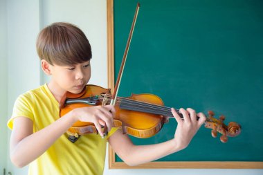 okul sınıfında keman çalan çocuk