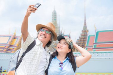Bangkok'ta seyahat ederken akıllı telefonla fotoğraf çeken yaşlı çift