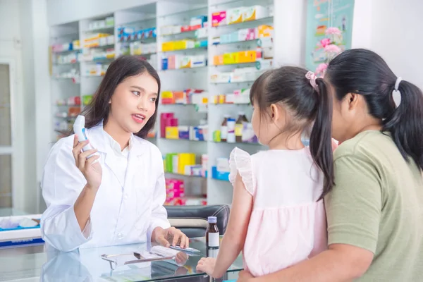 Farmaceuta wyjaśniający o cyfrowym termometrze pacjenta w aptece — Zdjęcie stockowe