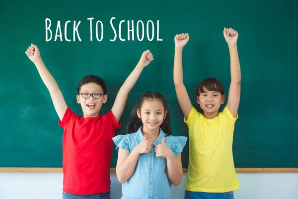 Three of young student standing in front of  chalkboard and smile — Stock Photo, Image