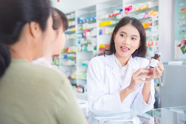 Farmaceuta wyjaśniający pigułki pacjentowi w aptece — Zdjęcie stockowe