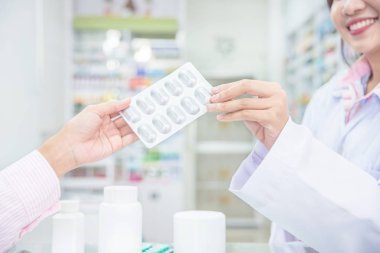 Hastaya ilaç veren eczacı ellere yakın 