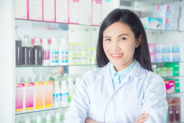 Farmacêutica feminina sorridente em pé na farmácia — Fotografia de Stock