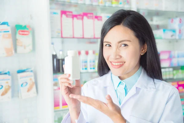 Usmívající se ženská lékárnice držící medicínu a úsměv — Stock fotografie