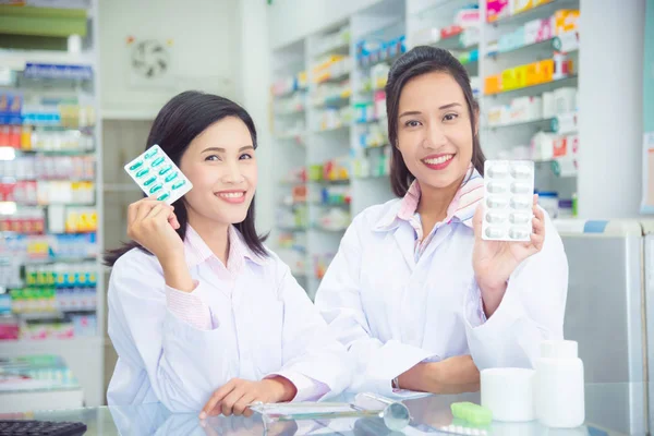 Deux asiatique femme pharmacien tenant la médecine et sourire — Photo