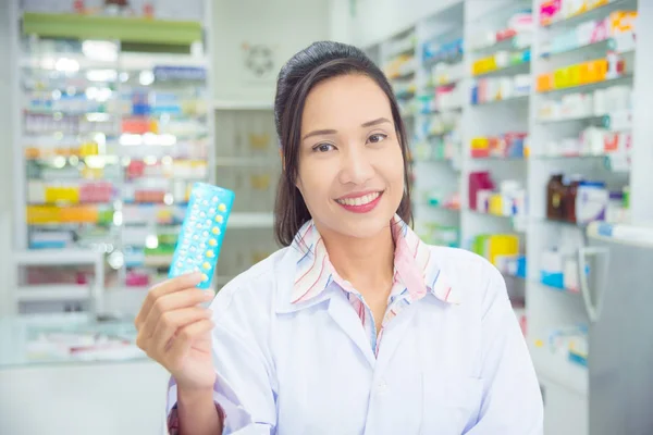 Une pharmacienne souriante tenant des médicaments et souriant — Photo