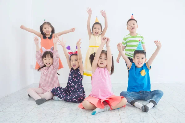Grupa dzieci podnieść ręce i uśmiech na imprezie — Zdjęcie stockowe