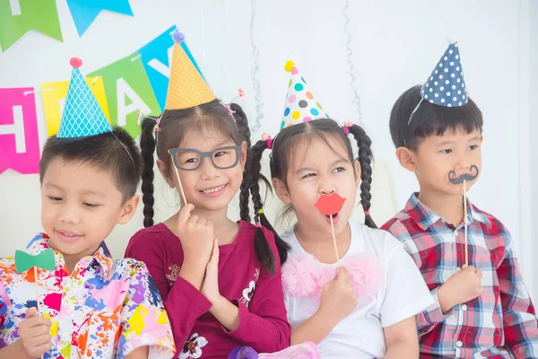 Grupa dzieci cieszyć się Holding party akcesoriów na przyjęcie urodzinowe — Zdjęcie stockowe