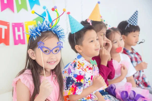 Mała Azjatycka dziewczyna trzyma okulary, party akcesorium z przyjaciółmi — Zdjęcie stockowe