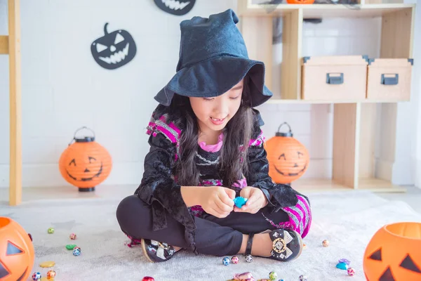 Malá holčička v Halloweenské čarodějnické maškarě, sedící na podlaze — Stock fotografie