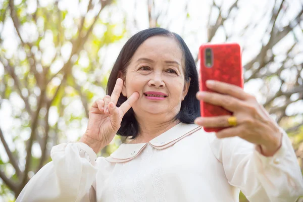 Mujer mayor tomando su foto por teléfono inteligente . — Foto de Stock