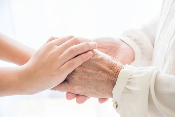 Close up of young girl holding senior hands. — Stock Photo, Image