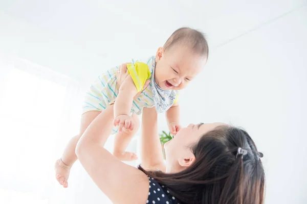 Petit enfant sourit joyeusement tout en jouant avec la mère — Photo