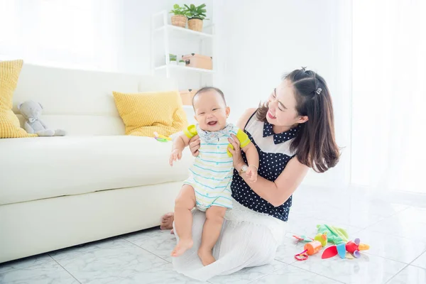 Klein kind glimlacht gelukkig tijdens het spelen met moeder — Stockfoto