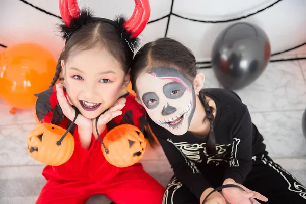 Kleine Mädchen im Halloween-Kostüm lächeln in die Kamera. — Stockfoto