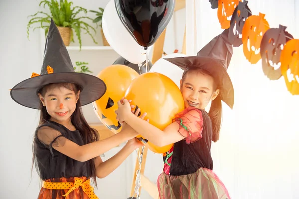 Dvě děti v kostýmech na čarodějnice stojí a usmívají se v pokoji — Stock fotografie