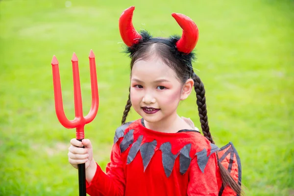 Flicka i djävulen kostym fira Halloween utomhus . — Stockfoto