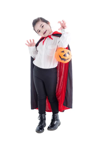 Longitud completa de la chica en traje de vampiro celebración de cubo de calabaza de Halloween y sonrisas — Foto de Stock
