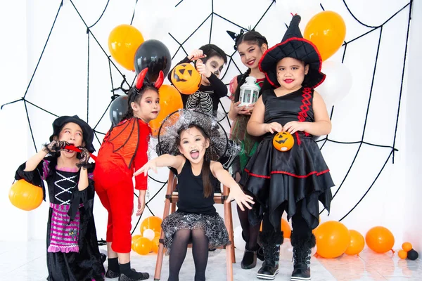 ハロウィンの衣装を着たアジアの子供たちのグループは 自宅でハロウィンパーティーを構成しています — ストック写真