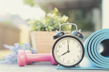 Saat, yoga mat ve masanın üzerinde halter egzersiz için zaman