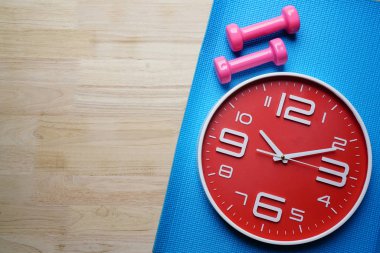 Saat ve yoga mat arka plan, spor ve sağlıklı kavramı üzerinde halter egzersiz için zaman